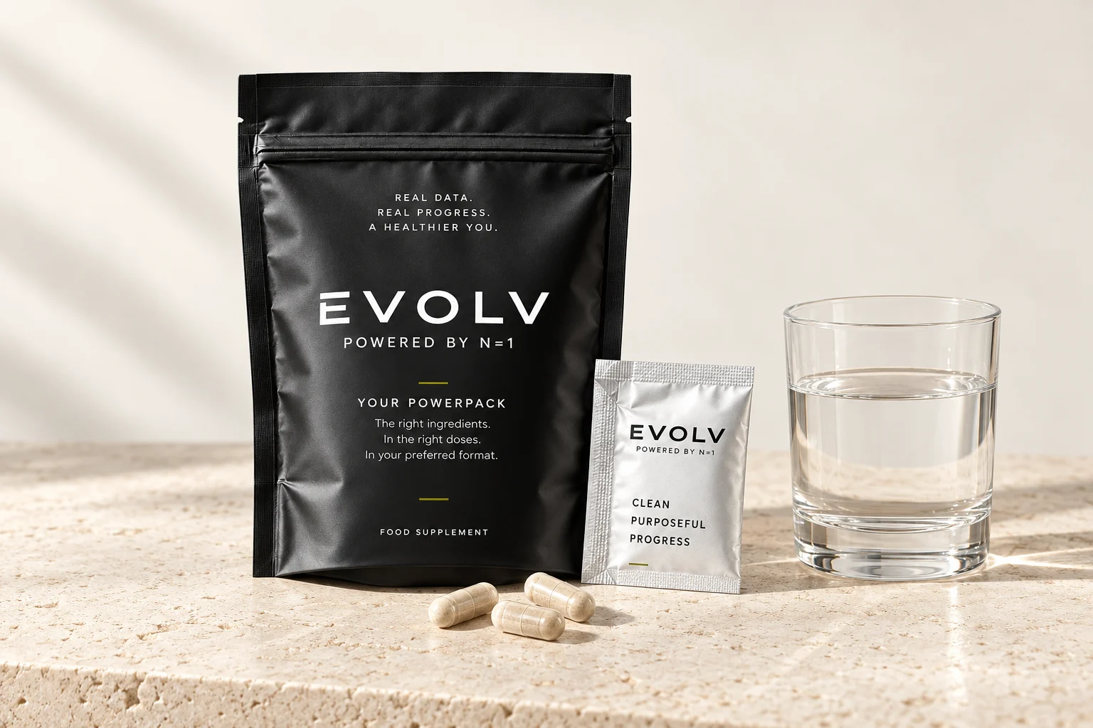 EVOLV Powerpack concept: black pouch, silver daily sachet, capsules and water